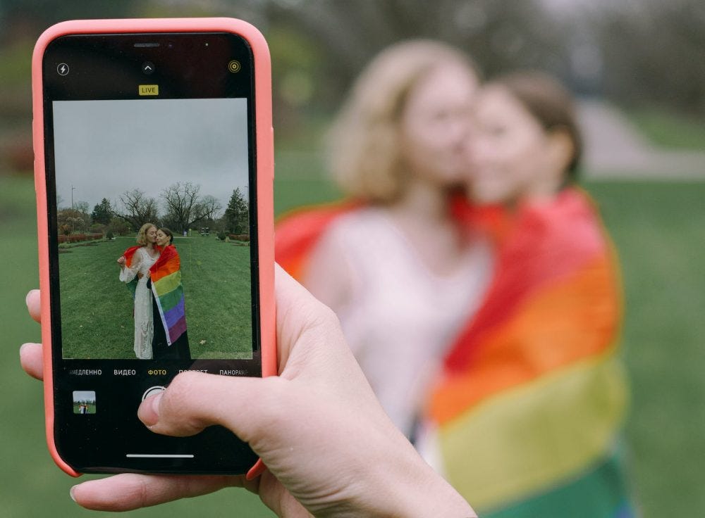 hand capturing photo of couple with smartphone