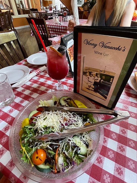 Pic 1: Vintage yellow car turning onto main street. Pic 2: Ivy sitting on an alpine sled. Pic 3: Stacy in front a mickey mouse sign saying Stacy's 50. Pic 4: Anne and Stacy wearing Mickey ears at an Italian restarurant. Pic 5: Fancy salad and cocktail on red checked tablecloth. Pic 6: Downtown Galena. Pic 7: Ivy selfie in Galena. Pic 8: Ivy, Anne, and black goat in the woods. Pic 9: Ivy and a black goat.