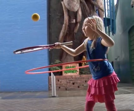 Kid bouncing a tennis ball in the air with a racket while hula-hooping. POET.