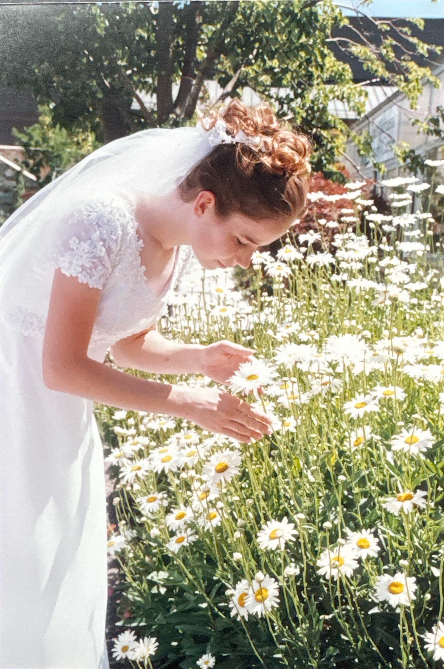 An image of a white woman bride bending to smell daisies in an outdoor field and an oil painting inspired by the photo