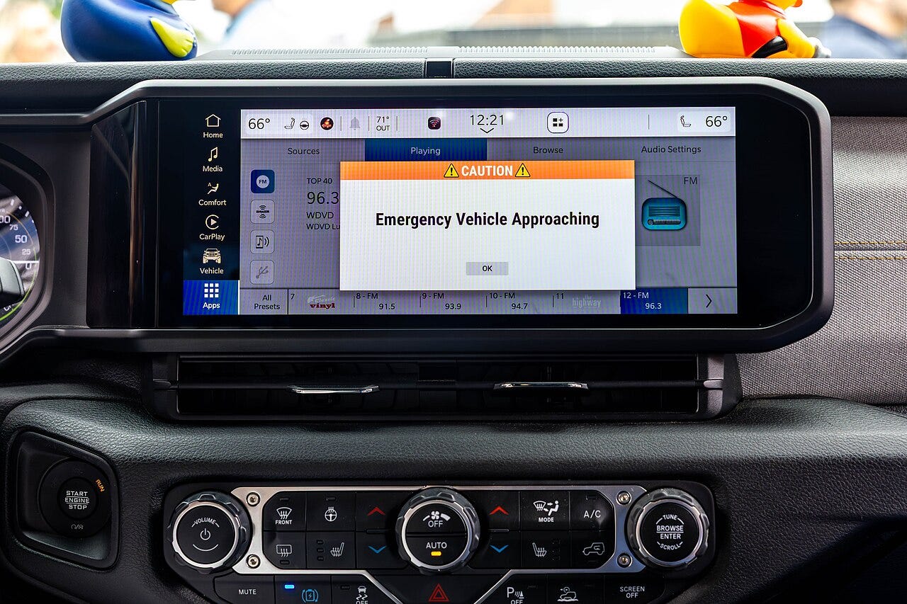 Photo: City of Detroit / Wikimedia Commons (CC0) A HAAS Alert message from an approaching emergency vehicle is displayed on the infotainment screen of a Jeep Wrangler during a technology demonstration in Detroit in 2025