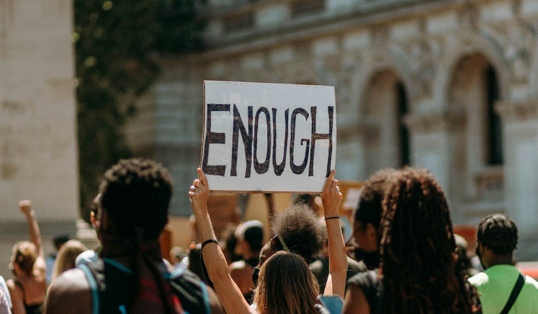 people holding a signage during daytime