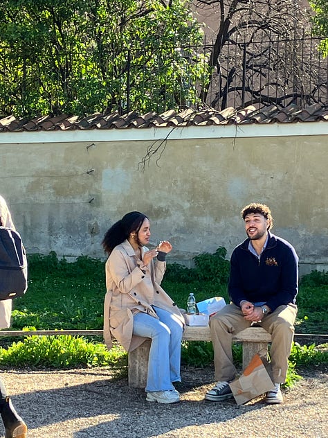 Una coppia è seduta vicina su una panchina in un parco, sotto un grande albero.  In un’altra immagine, due persone sono sedute su una panchina al sole mentre parlano e sorridono, con il prato alle spalle.  Nell’ultima, una coppia si abbraccia forte, davanti alla città.
