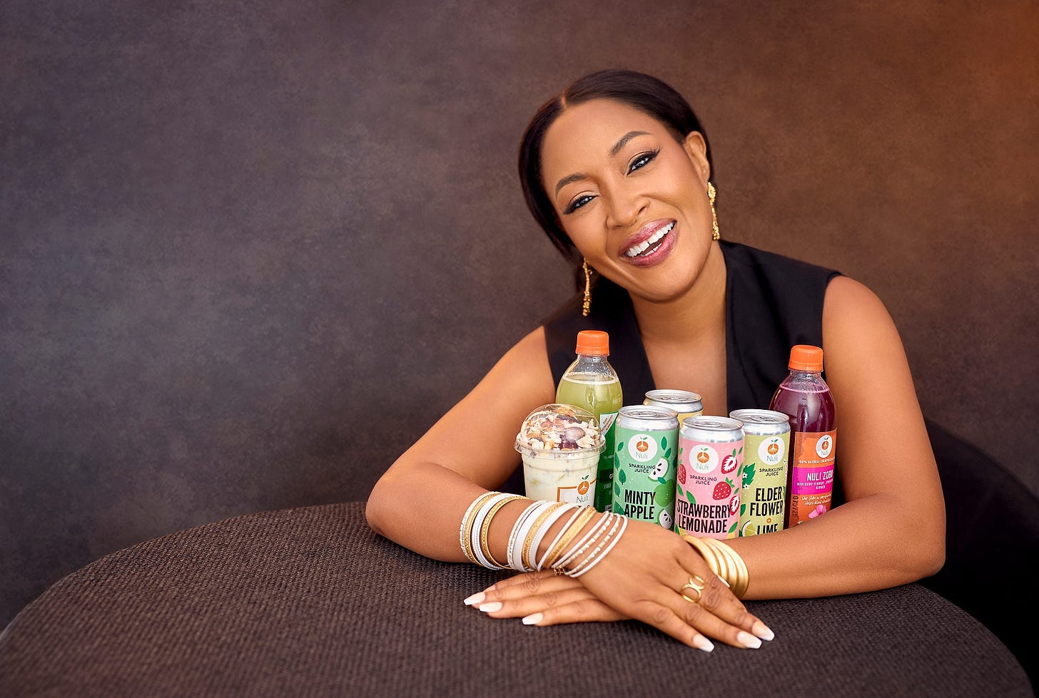 Ada Osakwe hugs an array of Nuli drinks and products.