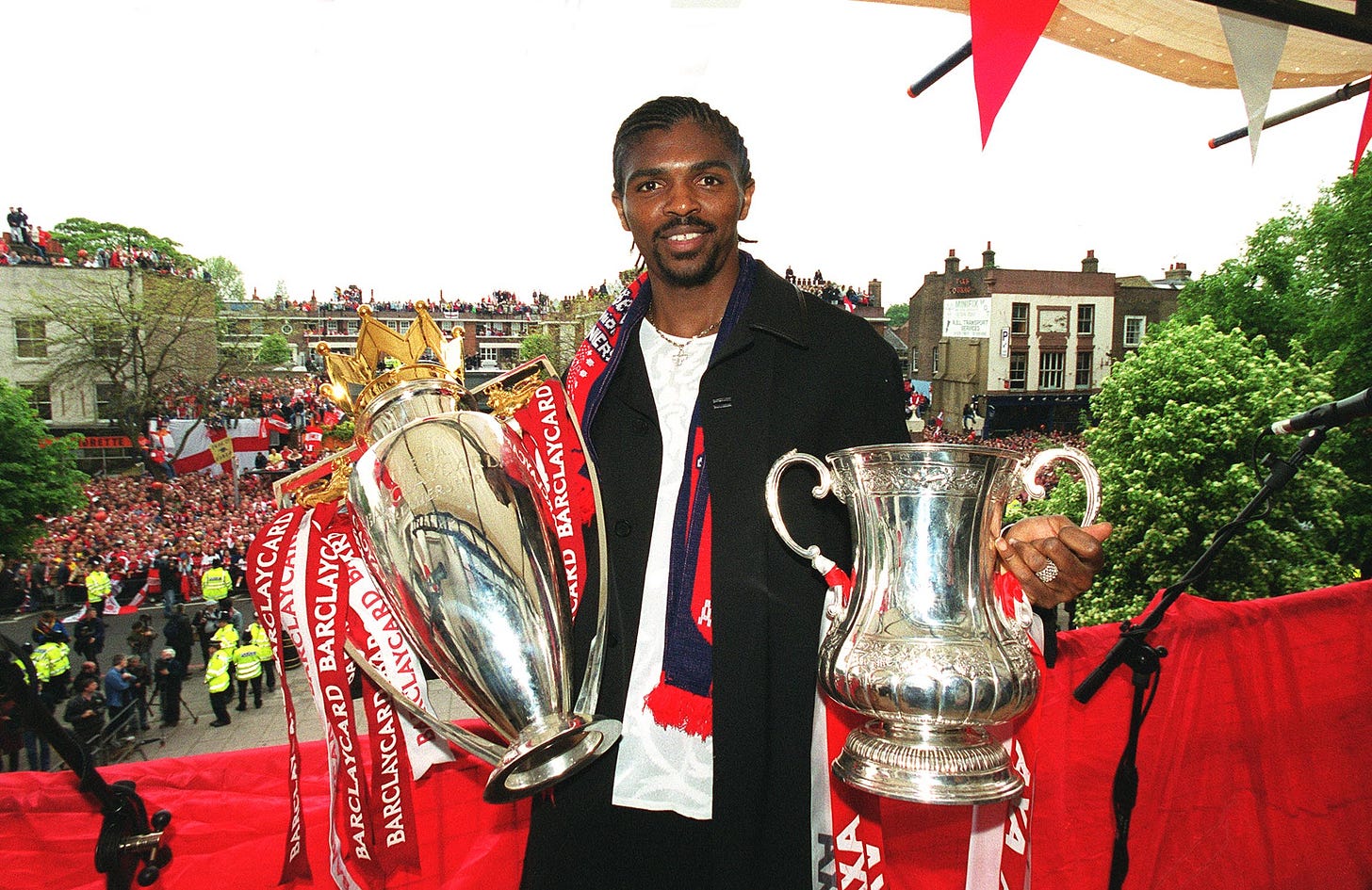 Kanu holding the Premier League and FA Cup trophy at Arsenal