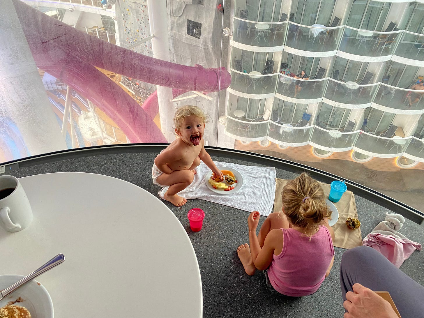 a baby and toddler enjoy a casual room service breakfast on their balcony