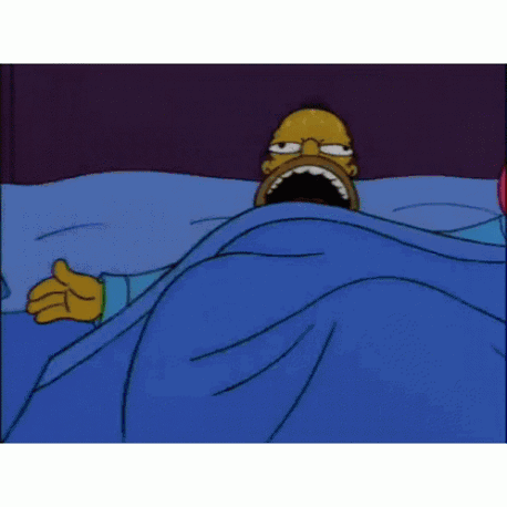homer simpson is laying in bed under a blue blanket .