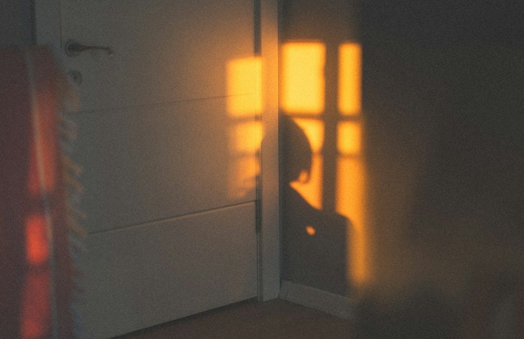 a person sitting in a chair in front of a door a person sitting in a chair in front of a door