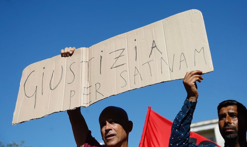 Un lavoratore regge un cartello per chiedere giustizia per Satnam Singh