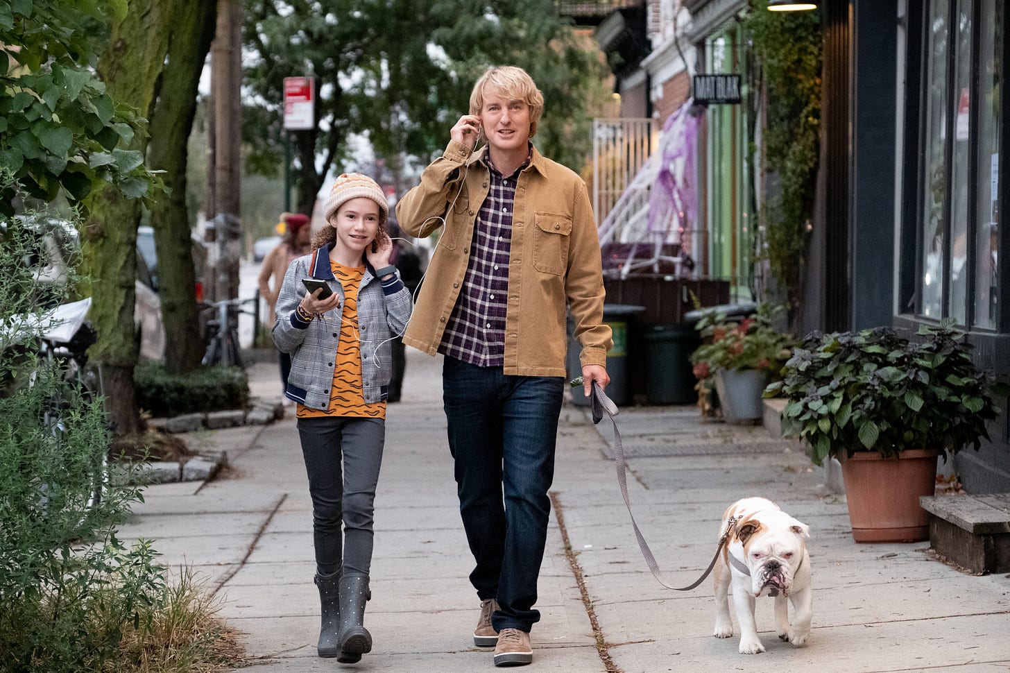 A father and daughter walk their bulldog.