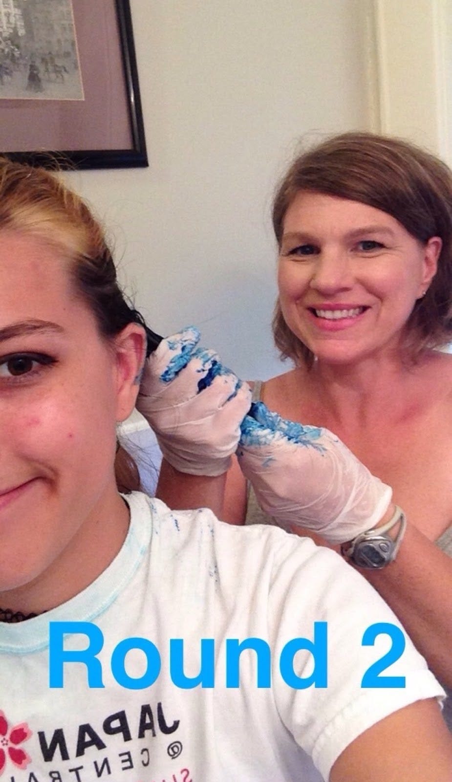 selfie of the author and their mom. their mom, treva, is wearing gloves stained blue with hairdye and holding a portion of Alekz's hair. Treva and Alekz are both smiling. The snapchat text over the picture says Round 2