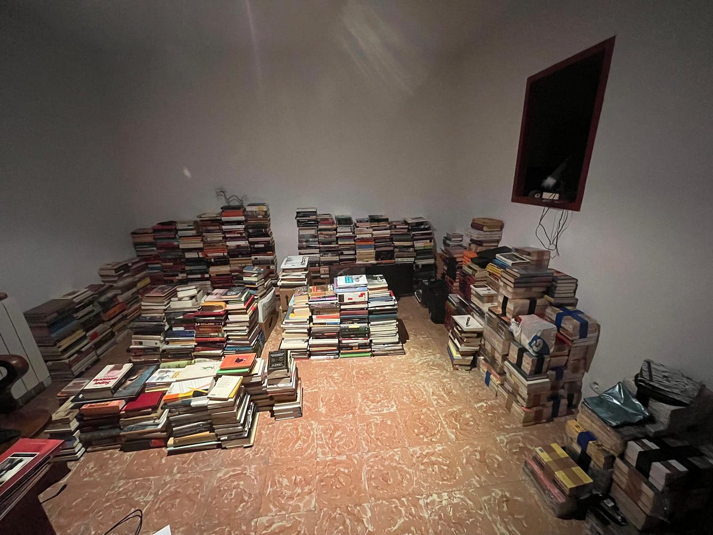 A room with lots of piles of books.