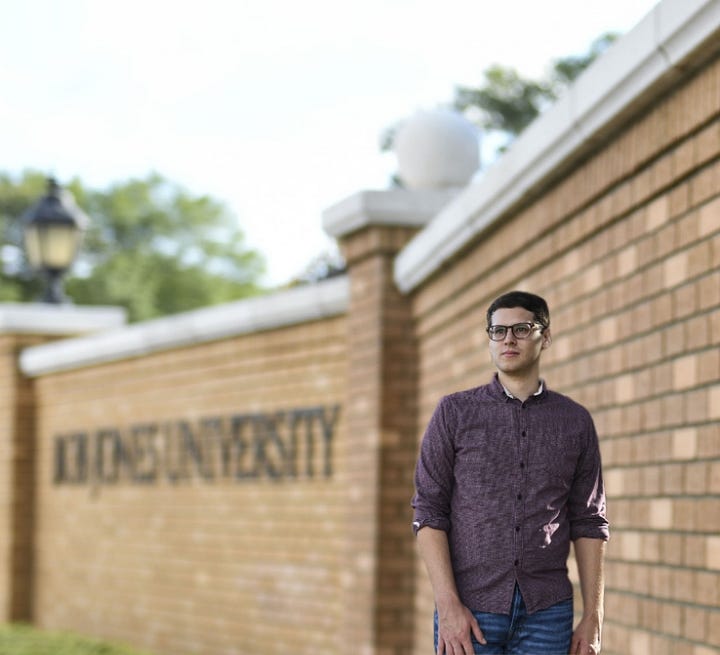 Andrew Pledger in front of the school that expelled him.