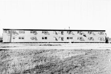 Photo: Birch Hall's 2 story facade expands across the open space, surrounded by lawn and natural landscaping and, with few trees, the full brightness of the sun
