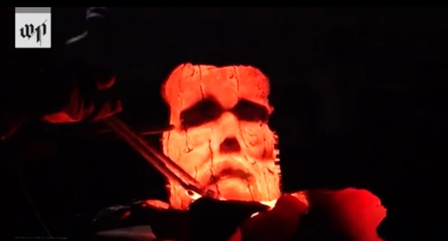 A carved face with a pair of tweezers

Description automatically generated