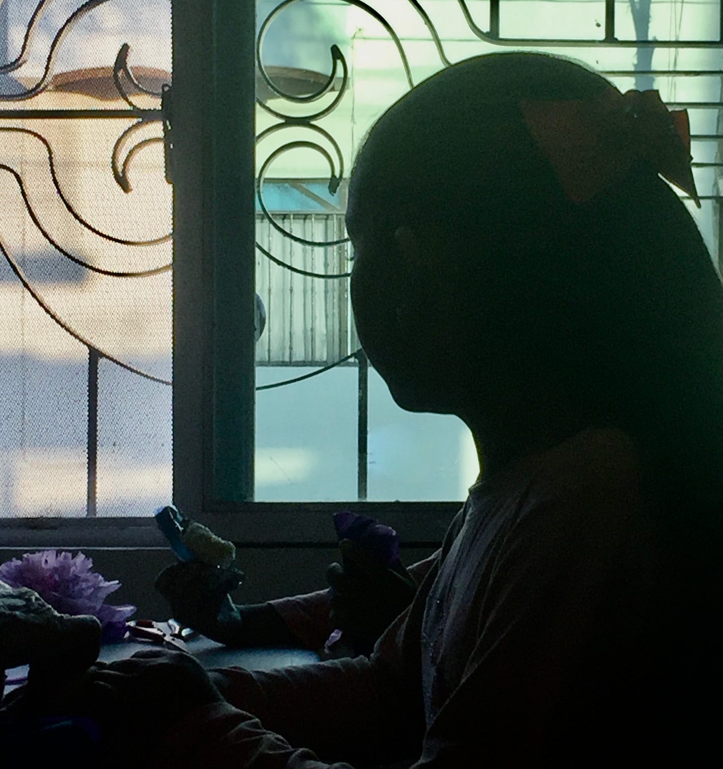 young girl looking out window