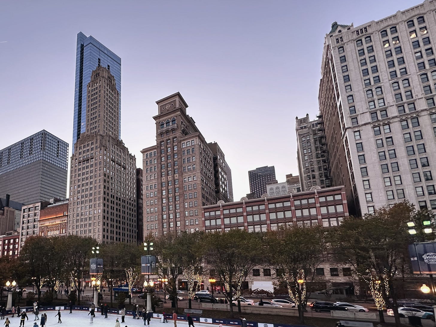 Golden hour cityscape capturing Chicago skyline, holiday lights, and ice skating at sunset.