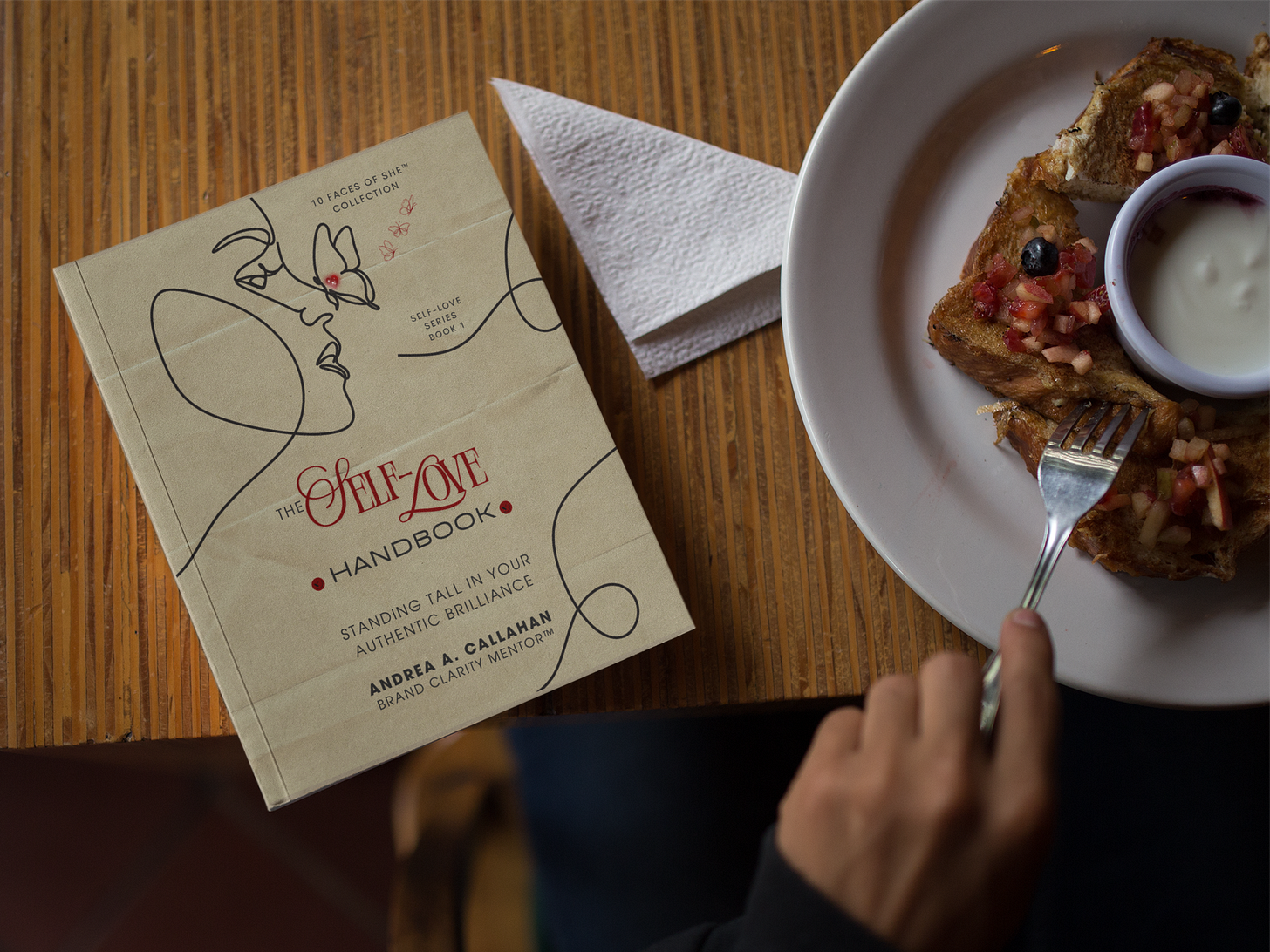 The Self-Love Handbook Standing Tall in Your Authentic Brilliance by Andrea Callahan woman reading over breakfast