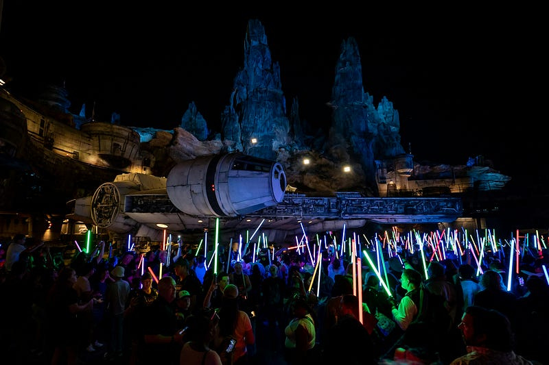 A crowd with lightsabers in hand