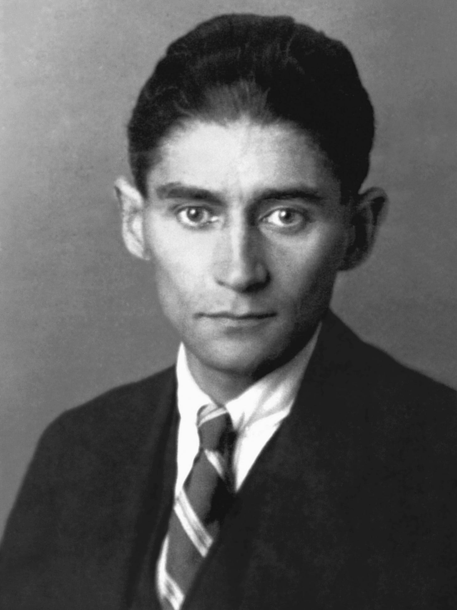 Franz Kafka in 1923, in a dark suit and a striped tie, looking straight into the camera. Franz Kafka in 1923, in a dark suit and a striped tie, looking straight into the camera.