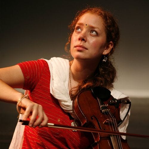 This may contain: a woman is playing the violin on stage
