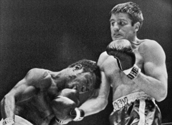 American boxer Emile Griffith, left, bends into a punch by Italian Nino Benvenuti during their middleweight championship bout on in Madison Square Gardens in New York, March 4, 1968. (AP Photo/File)