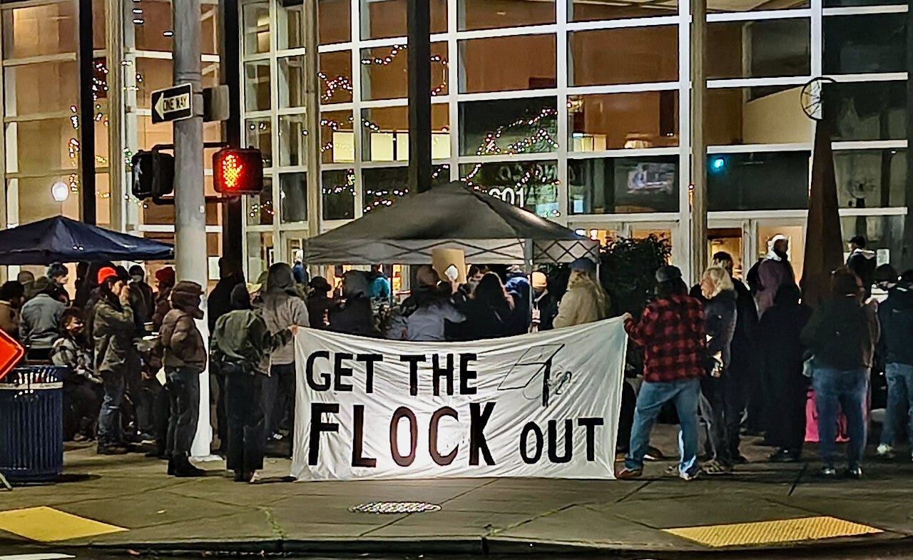 Dozens of people showed up outside of Olympia City Hall to protest the use of Flock cameras on Tuesday, Dec. 2, 2025.
