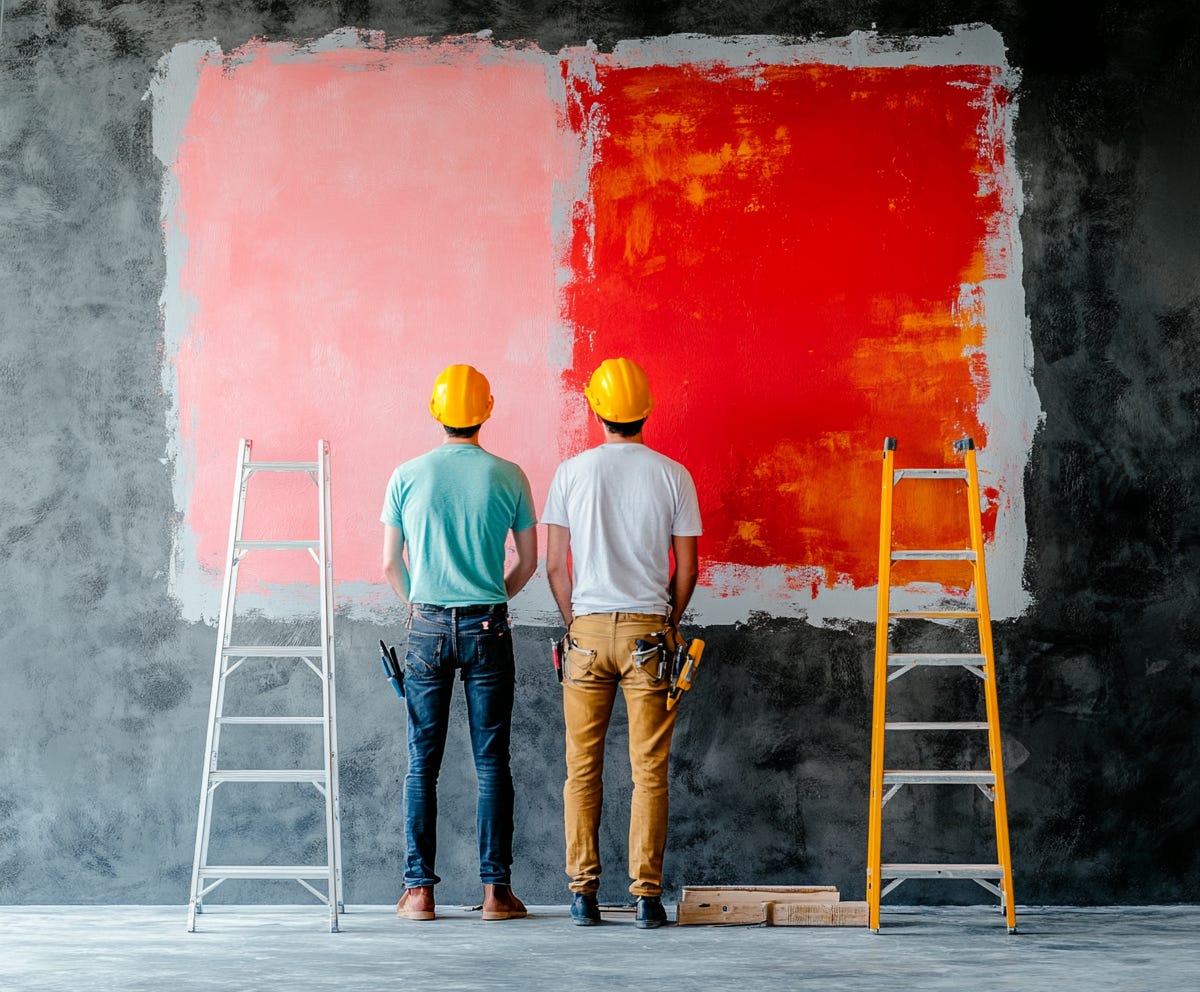 two tradies looking at patch tests of colour, one pink and one red, on a wall during a renovation, plush design interiors adelaide