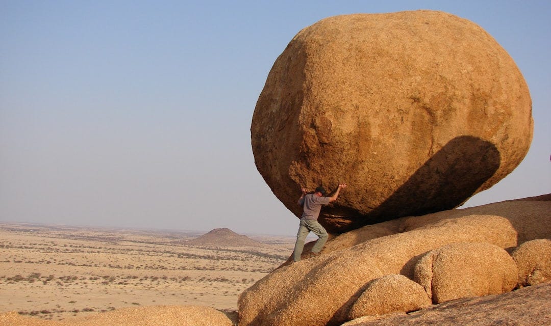 man standing beside rock formation man standing beside rock formation