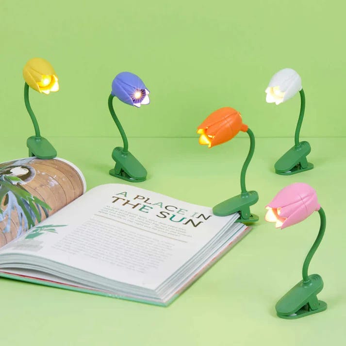 lámparas para lectura con forma de tulipán y pájaros de colores sujetas en libros