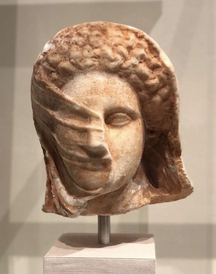 This may contain: a sculpture of a woman's head on display in a museum