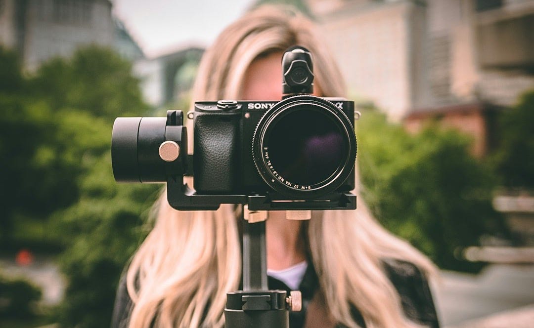 selective focus photography of woman holding camera gimbal