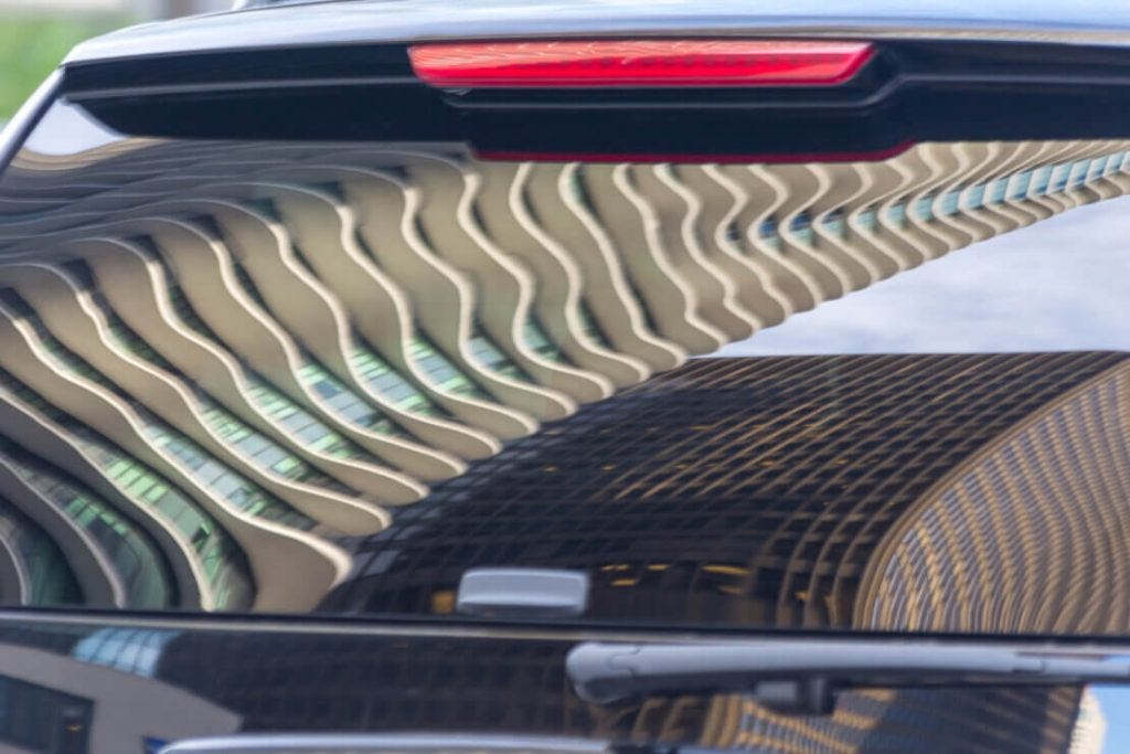 Aqua building reflections in a car window