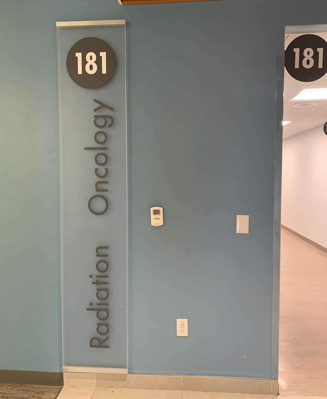 Signage on wall of the radiology department. Blue wall with the words Radiation Oncology 181