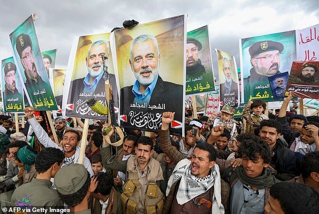 Yemenis wave flags and lift placards of Hezbollah senior commander Fuad Shukr, who was killed in an Israeli strike, and slain Hamas chief Ismail Haniyeh, during a rally in the Huthi-controlled capital Sanaa on August 2, 2024