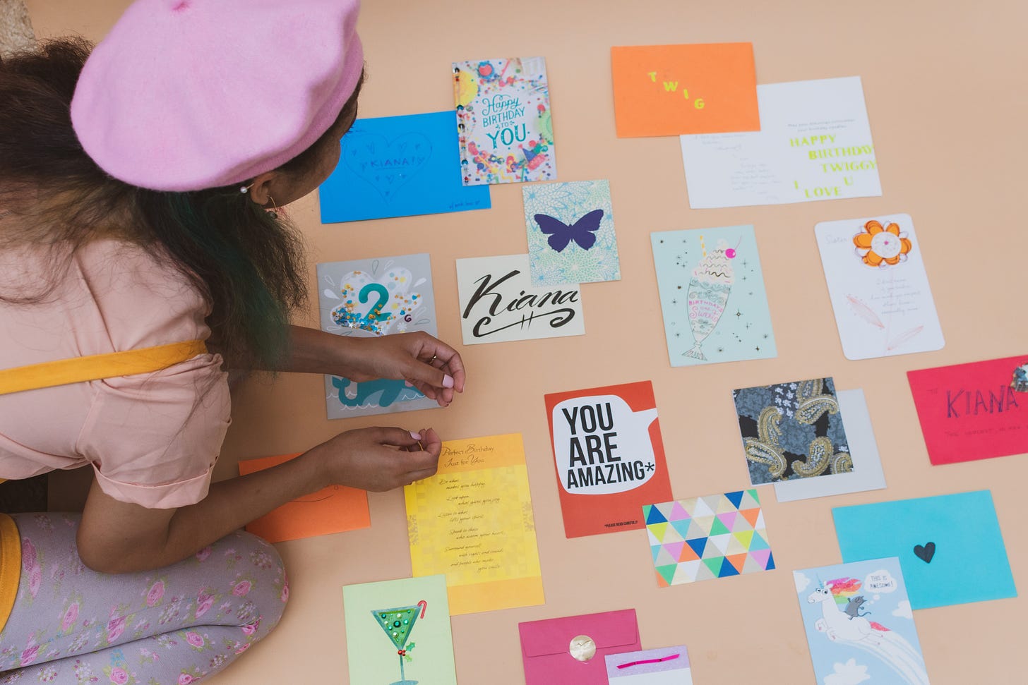 Kiana leaning over a plethora of bright cards of encouragement that others have written her