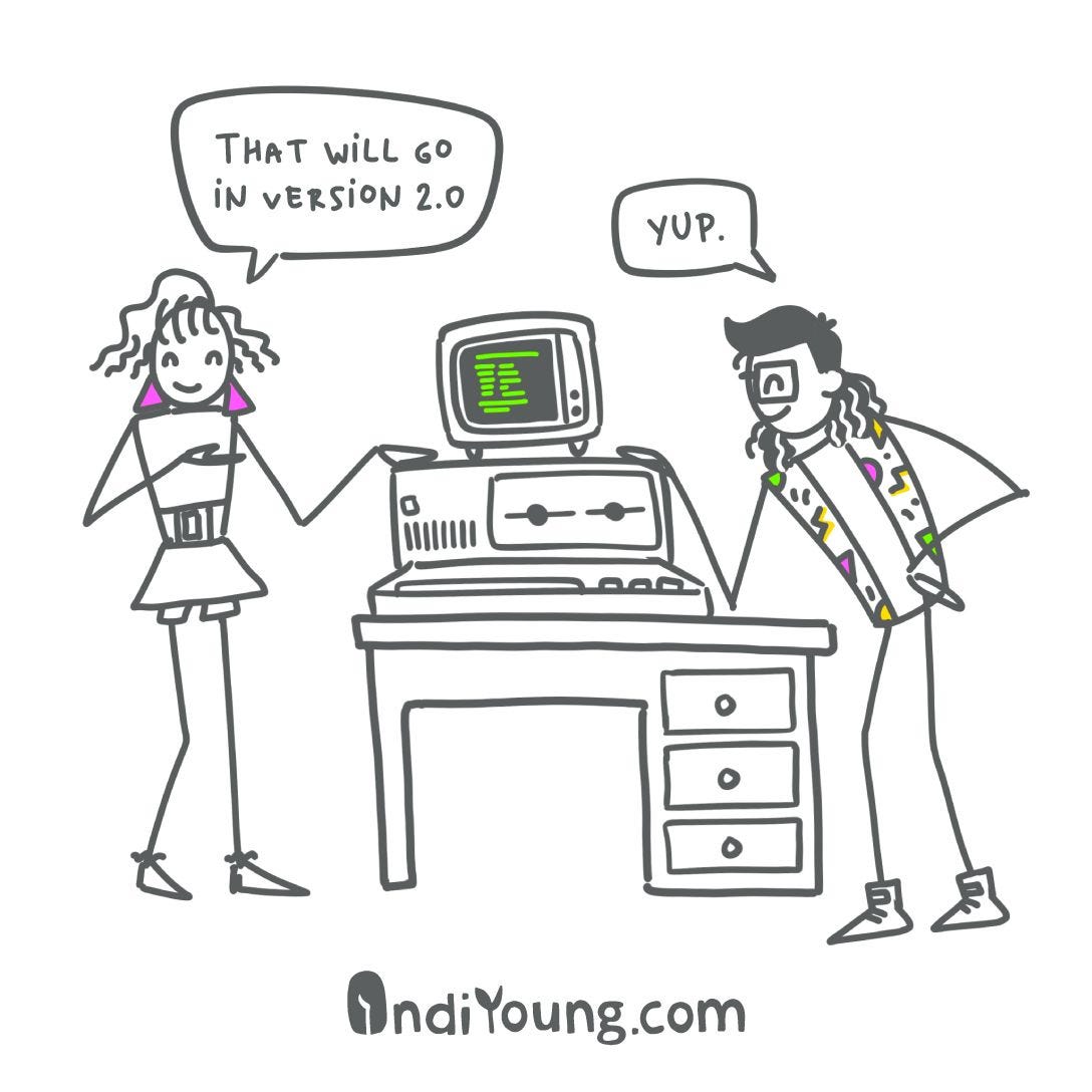 Two people in 80's clothing and hairstyles lean over either side of a desk with an old personal computer on it with floppy drive slots. The person on the left is saying, "That will go in version 2"