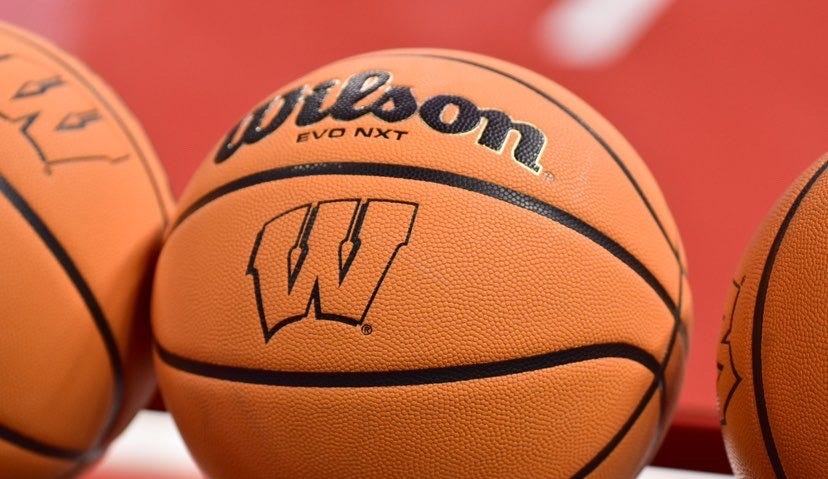 A Wisconsin Badgers-branded basketball rests on a ball rack inside the Kohl Center.