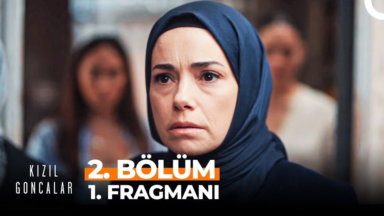 Başörtülü bir kadın karakter, Kızıl Goncalar dizisinin 2. bölüm fragmanında odak noktası olarak yer alıyor. Arka planda diğer karakterler ve bulanık detaylar bulunuyor.