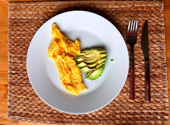 Turmeric porridge with seeds and berries next to eggs and avocado—protein-first autumn breakfast for stable glucose.