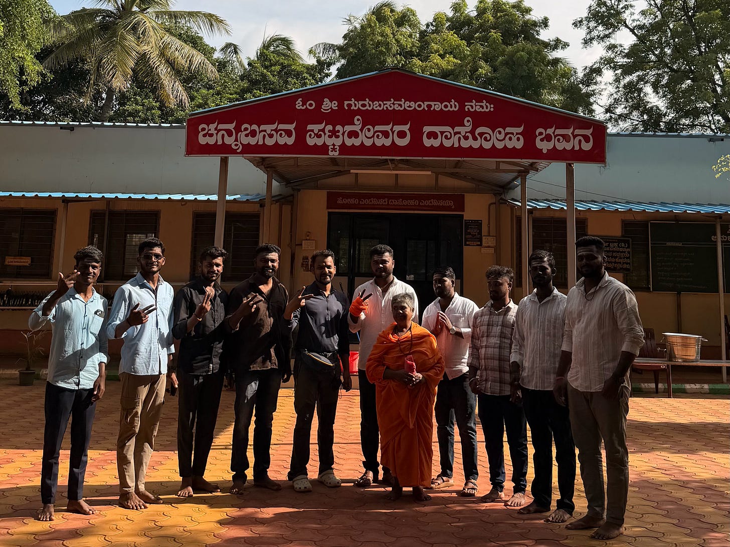 Image shows people standing in front of the Dasoha bhavana and posing for a photo. Image shows people standing in front of the Dasoha bhavana and posing for a photo.