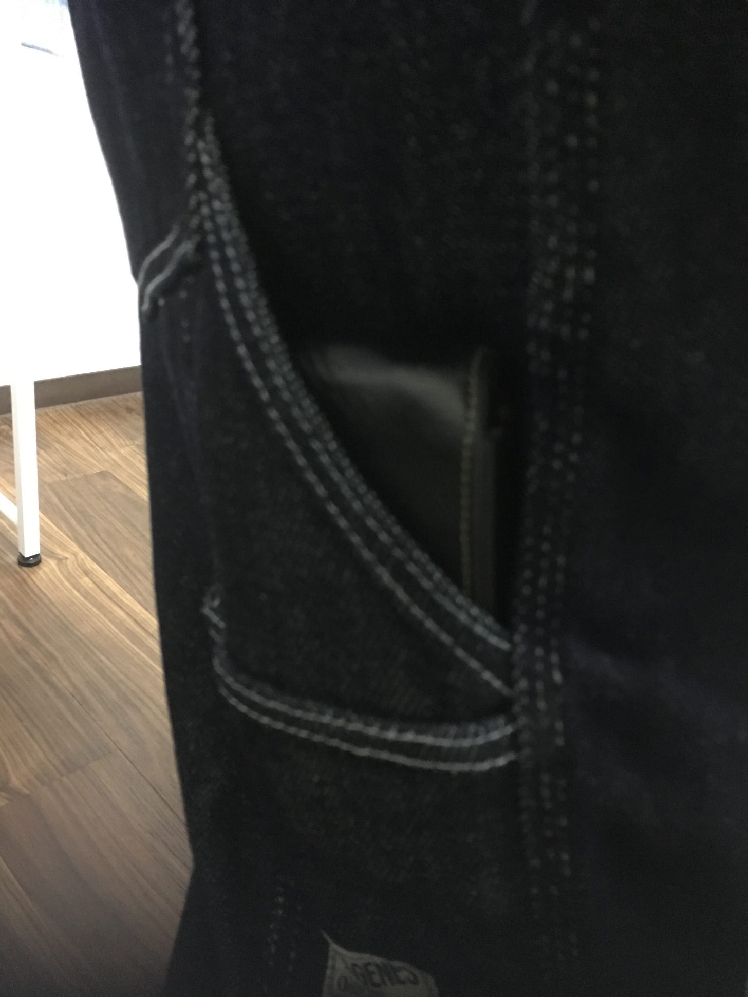 A side pocket on a pair of denim painter's pants, with a pen case within.