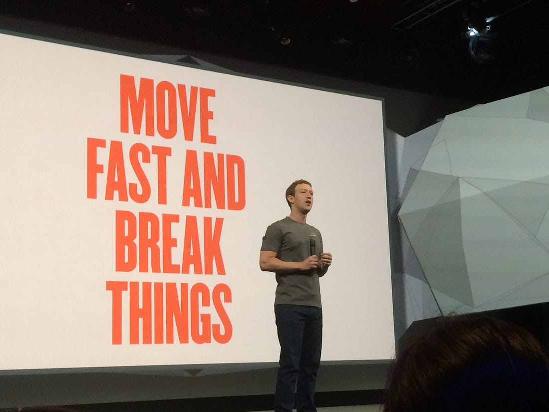 Mark Zuckerberg on stage in front of the slogan “Move fast and break things,” representing startup hustle culture.