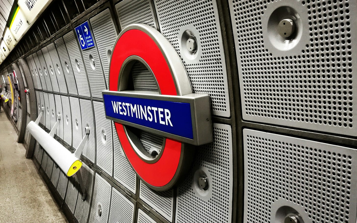 A London tube station, with a red and blue sign labelled "Westminster" A London tube station, with a red and blue sign labelled "Westminster"