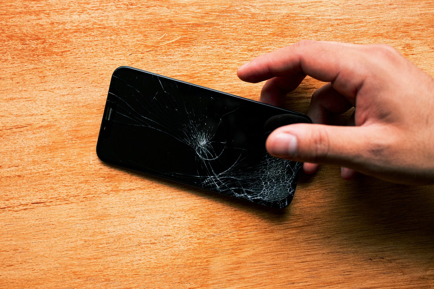 A hand holding a broken phone
