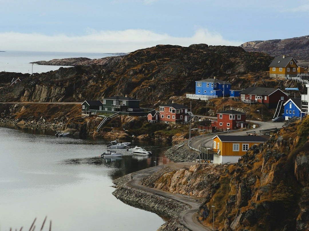 A body of water surrounded by mountains and houses A body of water surrounded by mountains and houses