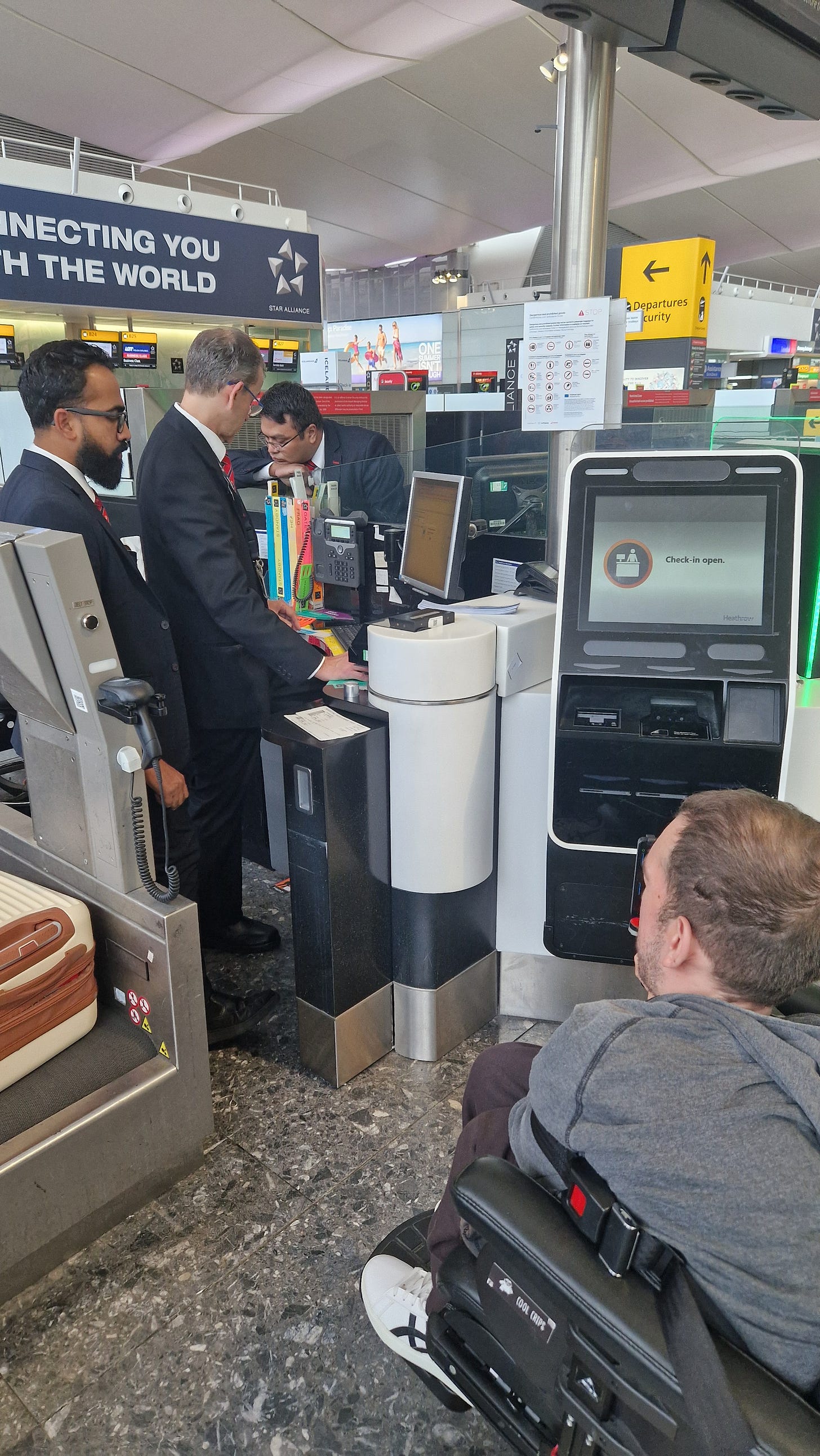 Me at a check-in trying to explain to three desk officers that I am ok to fly