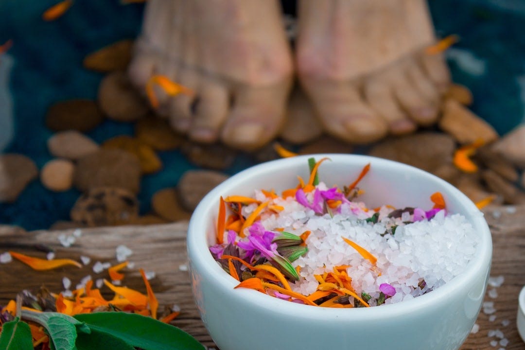 a bowl of sea salt with flowers in it