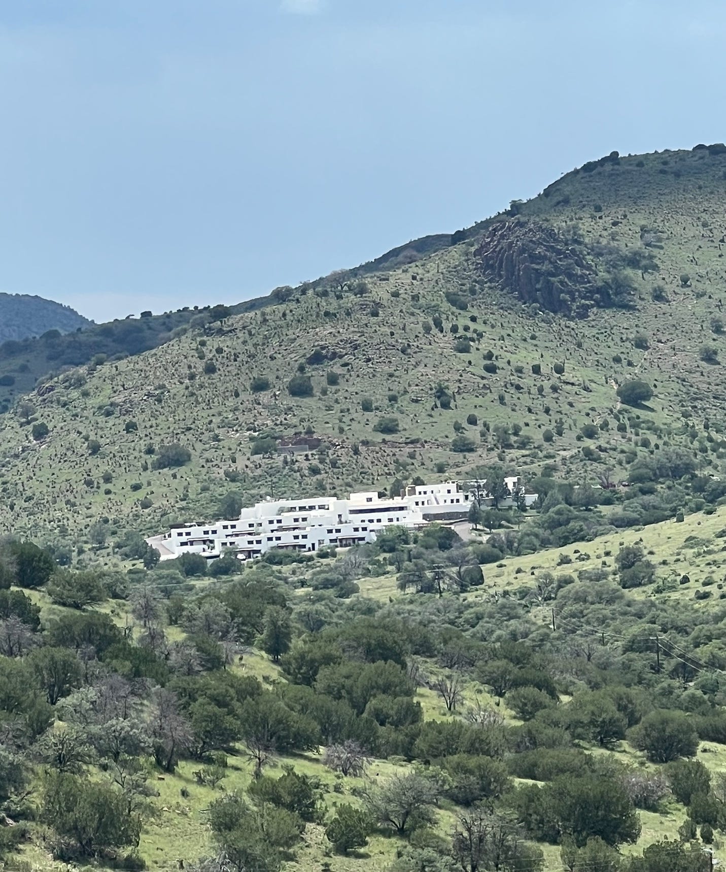 A building in the middle of a green hill

Description automatically generated