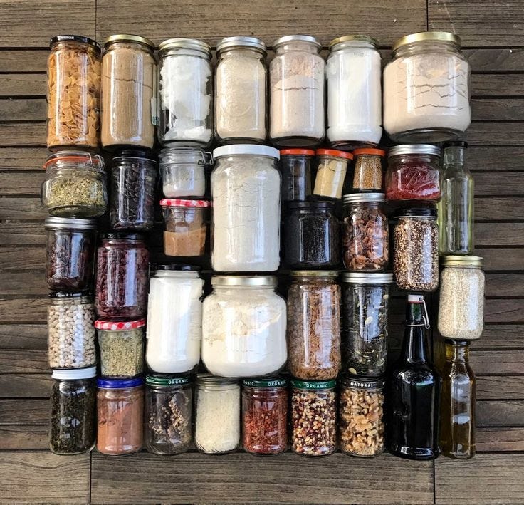 This may contain: an assortment of spices and condiments are arranged on a wooden surface in rows